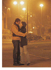 Photo of a man and  woman embracing in a hug at night