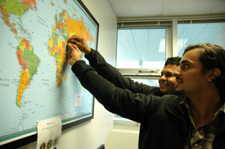Veterans add push pins to a world map in the new Veterans Services Center, marking the location of their last deployment. 