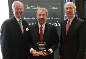 A photo of President Corrigan with the award, flanked by the presenters.