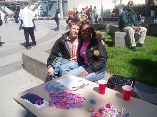 Two students next to the table of free condoms