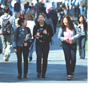 Photo of three students walking across campus