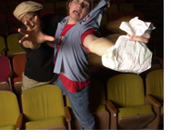 Photo of two actors in a movie theater reaching their hands towards the camera