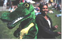 Photo of the Gator mascot standing next to a student