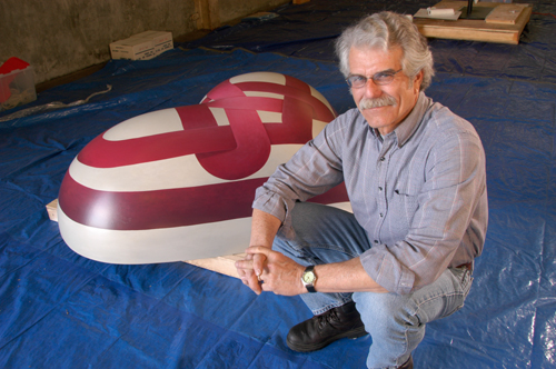 Photo of SFSU faculty member and artist Paul Pratchenko next to the heart sculpture he created