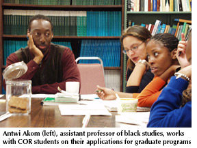 Photo of Antwi Akom, assistant professor of black studies, working with COR students on their applications to graduate programs 