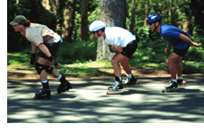 Photo of three people rollerblading through a wooded area 