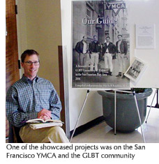 Photo of one of the students from the showcase with his poster presentation on the San Francisco YMCA and the GLBT community