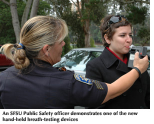 Photo of an SFSU Public Safety officer demonstrating one of the new hand-held breath-testing devices