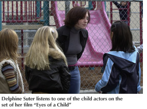 Photo of Delphine Suter on the set of her film "Eyes of a Child" listening to one of her child actors