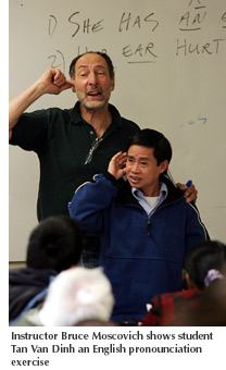 Photo of ESL instructor Bruce Moscovich showing student Tan Van Dinh an English pronounciation exercise