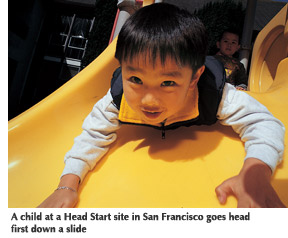Photo of a child at a Head Start site in San Francisco going down a slide head first