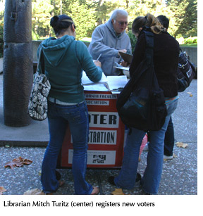 Librarian Mitch Turitz registers voters at a table in front of the J. Paul Leonard Library