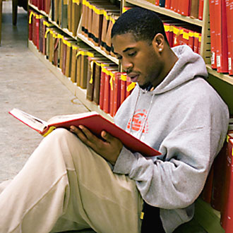 Photo of African American student reading in SF State library.