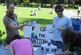 Douglas Johnson and Kevin Deniz, members of ECO Students, promote Focus the Nation with free energy-efficient light bulbs.