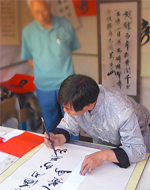 Photo of a young man writing in Chinese.