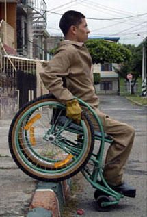 Photo of Arnulfo Criollo using his Whirlwind RoughRider wheelchair to navigate a ramp-less curb in Colombia.