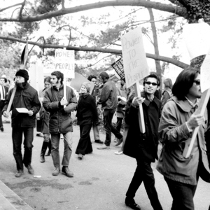 A black and white photo of the San Francisco State student strikers marching and holding strike placards on campus.