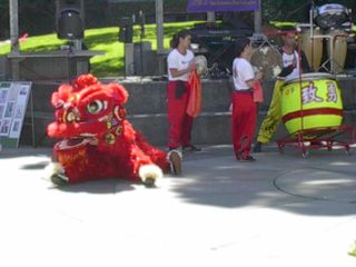 One lion dancer, in costume, next to the drummer