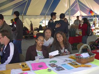 Three peer educators at a table in the tent