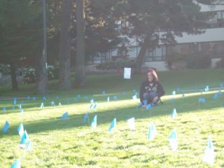One student sitting in the middle of the flags on the Quad