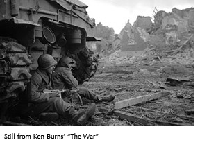 Still from Ken Burns' "The War" showing two soldiers leaning against a tank