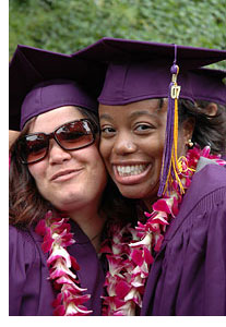 Photo of two female graduates in their Commencement regalia