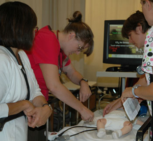 Photo of SF State nursing students examining a patient, an infant simulator.