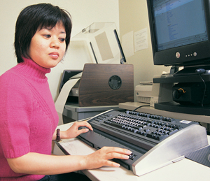 Photograph of a person using a computer with the aid of assistive technology.