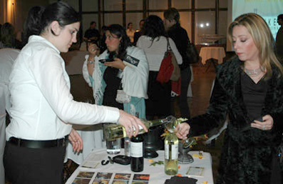 A photo of a woman pouring wine in a glass at Taste of the Bay.