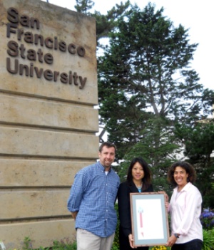A photo Nina Roberts and Drew McAdams receiving a resolution presented by Fiona Ma