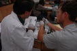 A photo of Matthew Snyder and Joe Issel comparing the inside of their fish's head to the lab manual.